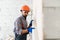 Builder at facade plastering work during industrial building with putty knife float