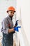 Builder at facade plastering work during industrial building with putty knife float