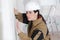 Builder female indoor worker plastering wall