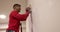 Builder foreman standing on ladder smoothes plastered wall