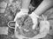 Builder hands holding wet yellow sand in working safety gloves.