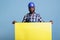 Builder in hard hat holding large empty yellow banner