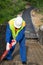 The Builder holds a red pipe for laying electrical cables in parks before pouring the Foundation of the road