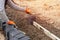 Builder installing paving blocks during road and footpath construction on semi-dray concrete mix