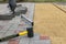 A builder installs concrete blocks for sidewalks in the courtyard of a country house. Selective focus