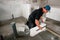 Builder laying bricks indoors