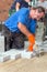 Builder laying paving stones with his team.