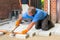 Builder levelling paving stones as he lays them.