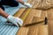 The builder, man is engaged in laying laminate wood floor in the room - repair and finishing work.