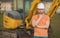 Builder near excavator. Builder worker with excavator. Builder in helmet. Worker in hardhat. Portrait mechanical worker