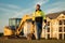 Builder near excavator. Builder worker with excavator. Builder in helmet. Worker in hardhat. Portrait mechanical worker