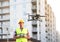 Builder operating drone with remote control at construction site. Aerial photography