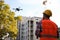 Builder operating drone with remote control at construction site. Aerial survey