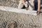 Builder placing edging pin kerb on semi-dry concrete using a string line to keep them straight during construction of  footpath