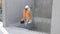 Builder repairman, foreman in protective helmet and vest stands at workplace in building and holds ruler and toolbox in hands