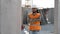 Builder repairman in safety helmet stands at his workplace with his arms crossed in front of him