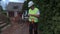 Builder with spade and tablet near tractor