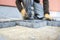 Builder tamping down a new paving slab or brick with motion blur