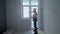 A builder in uniform checks the size and quality of window installation in a new apartment