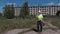 Builder with walkie talkie walking near abandoned apartment houses