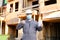 Builder wearing mask and hardhat showing disinfectant.