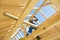 Builder at work with wooden roof construction.