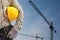 Builder worker in uniform and helmet operating with tower crane