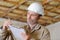 Builder writing on clipboard indoors