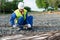 Builder in a yellow vest takes long iron rods