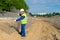 The Builder in a yellow vest and a white helmet, opens a box of mesh to check the design