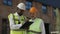 Builders with clipboard having meeting at construction site