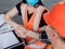 Builders in helmets, vests and medical masks shake hands after signing the contract for the construction of the building