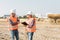 Builders in orange vests and helmets working on the road construction field