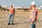 builders in orange vests and helmets working on the road construction field