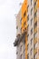 Builders paint the facade of a high-rise residential building