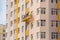 Builders paint the facade of a high-rise residential building