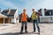 Builders standing with hands on hips outside