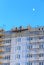 Builders on the wall of a multi-storey building against the sky and moon