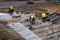 Builders working on construction foundation. Man strengthen concrete structure on the hill slope