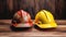 builders yellow and red safety helmets on the table on a wooden background