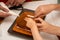 Building assembling of a gingerbread house with royal icing in four hands. Christmas family moments concept