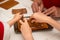 Building assembling of a gingerbread house with royal icing in four hands. Christmas family moments concept