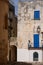 Building with blue shutters on a street in the coastal town of Otranto on the Salento peninsula, Puglia, South Italy.