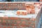 Building a brick foundation wall corner of a house construction using spirit level to keep the brickwork upright and level on a