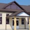 Building with a brown roof. The main entrance to the house. Modern materials of finish and