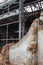 Building and construction materials for sale stored on metal shelves outdoors in a warehouse yard together with wooden pallets for