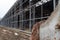 Building and construction materials for sale stored on metal shelves outdoors in a warehouse yard together with wooden pallets for