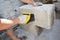 A building contractor is cutting autoclaved aerated concrete block, gas concrete using a hand saw on a construction site