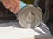 A building contractor is cutting white ceramic tile using an angle grinder or disc grinder