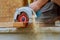 Building contractor worker using hand held worm drive circular saw to cut boards on a new home constructiion project